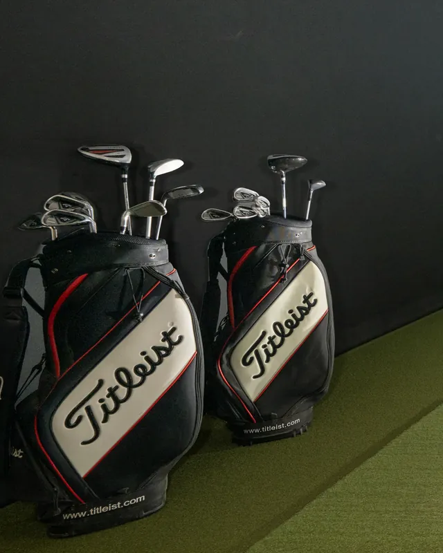 Two bags of house clubs standing in a bay, free to use.