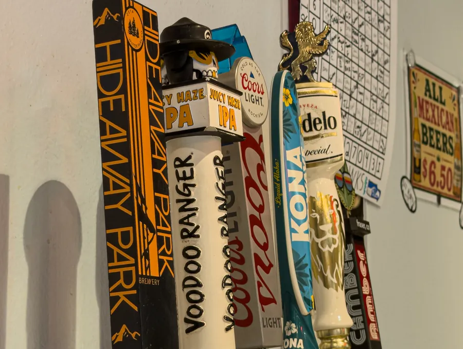 The six tap handles on the bar: Hideaway Park, Voodoo Ranger Juicy Haze, Coors Light, Kona, Modelo and Camber.